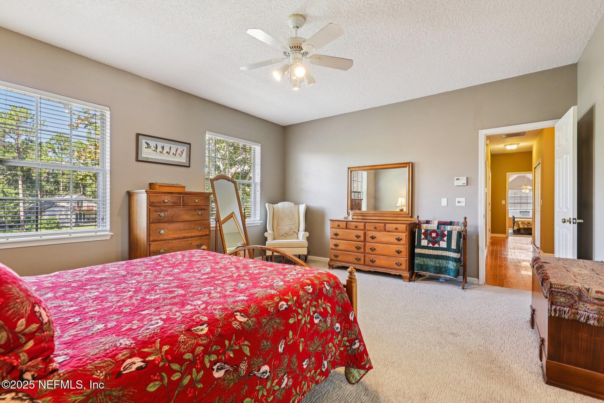 1432 Course View Drive Fleming Island, FL 32003 - Photo 42 of 83 a bedroom with a large bed and a chandelier