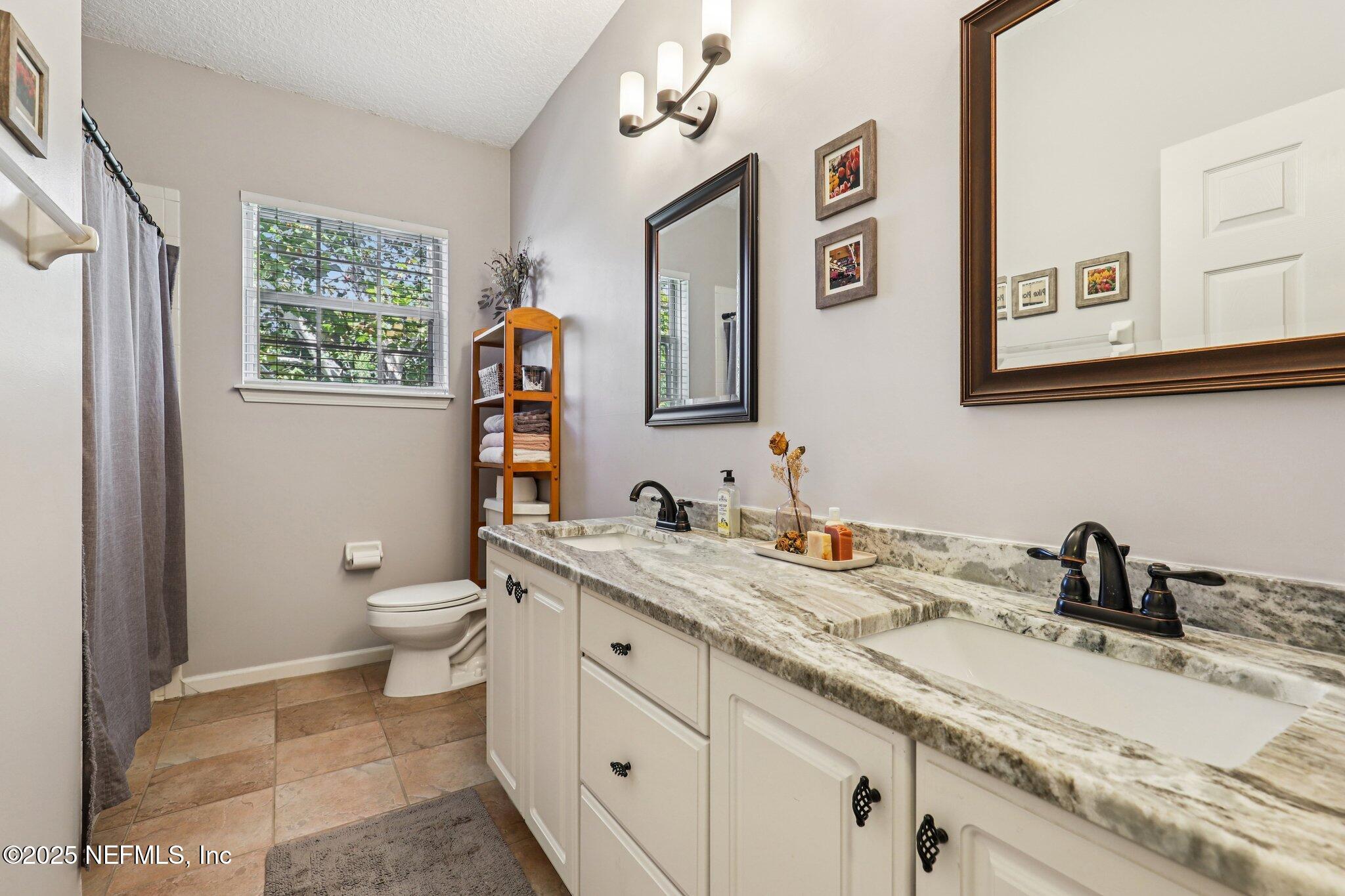 1432 Course View Drive Fleming Island, FL 32003 - Photo 10 of 83 a bathroom with a granite countertop sink mirror and toilet