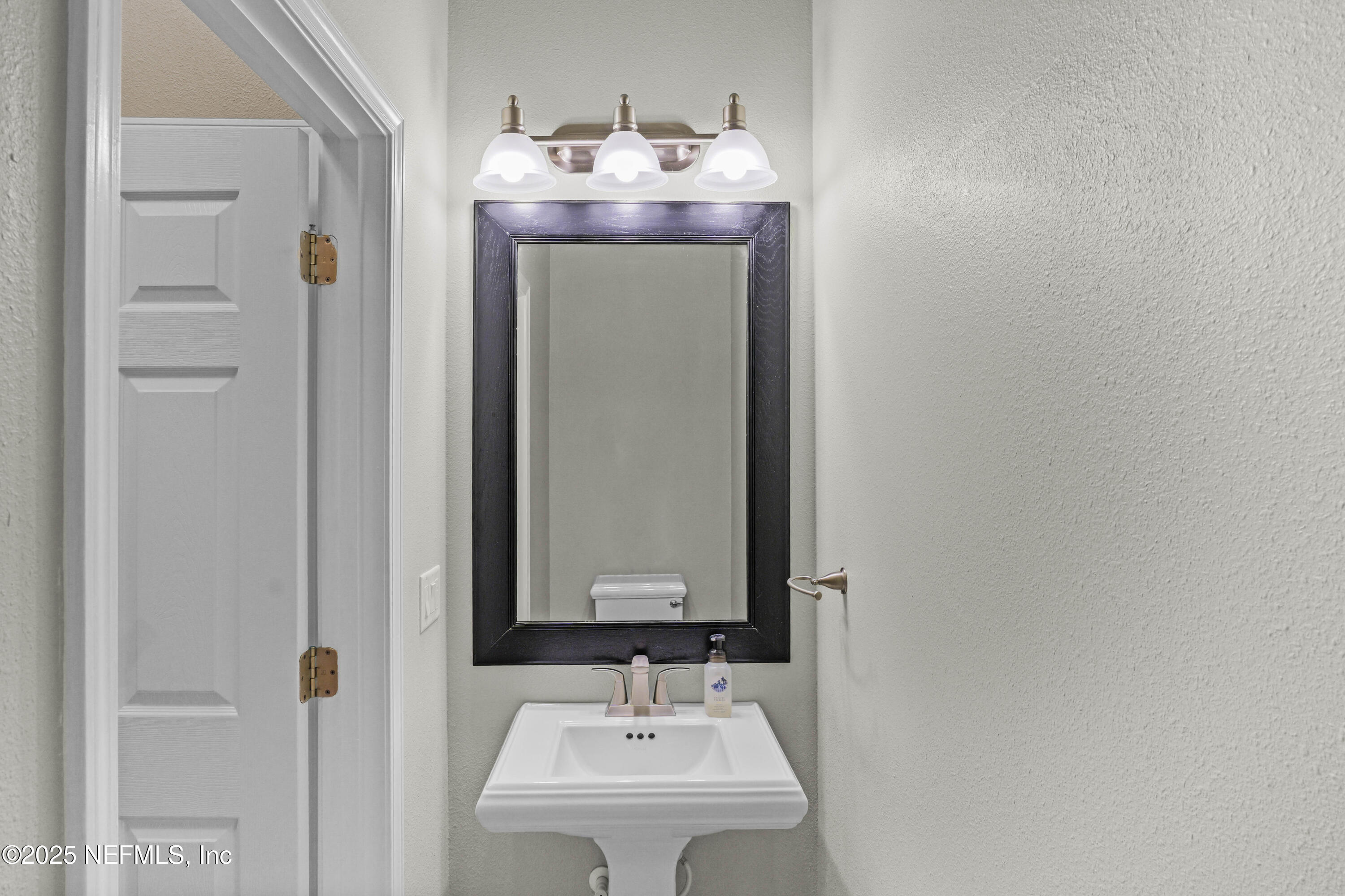 96218 Windsor Drive Yulee, FL 32097 - Photo 47 of 53 a bathroom with a sink and a mirror