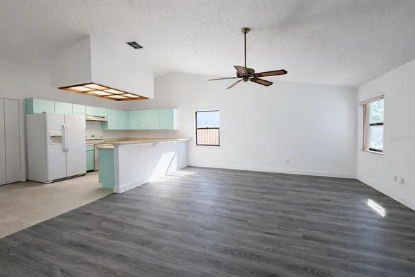 a view of empty room with wooden floor and window