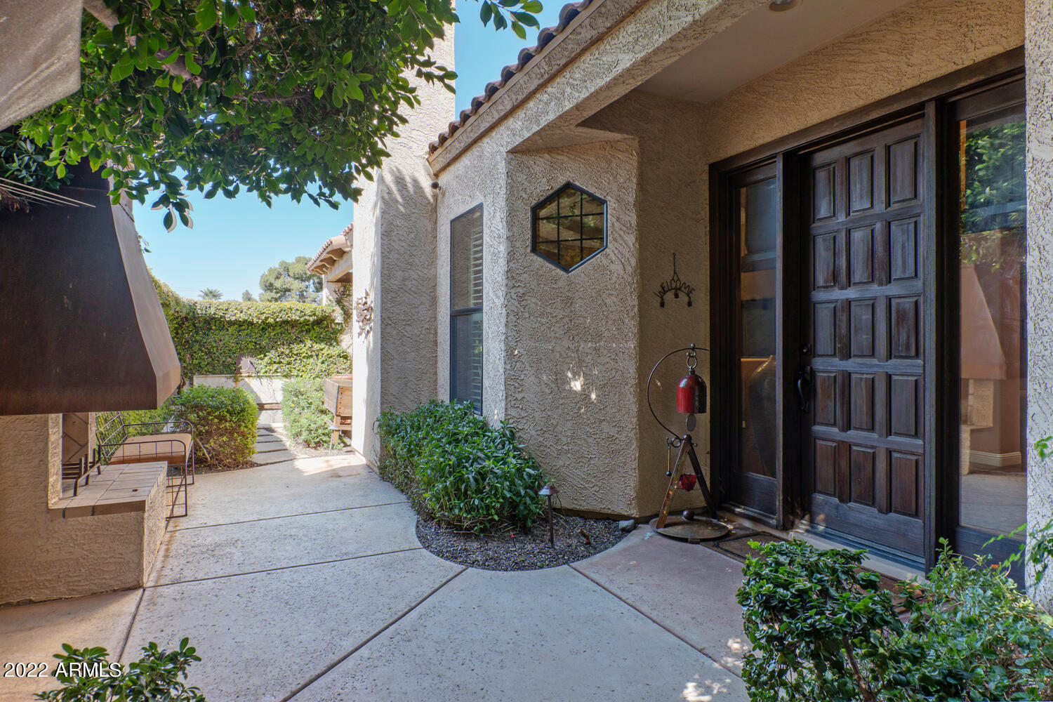 8100 East Camelback Road, Unit 39 Scottsdale, AZ 85251 - Photo 2 of 40 Entry flanked by copper hooded fireplace