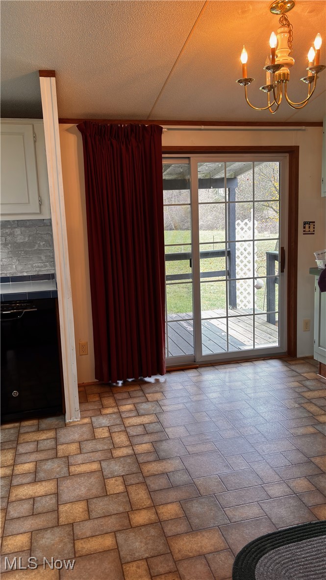 2090 Big Flint Road Salem, WV 26426 - Photo 10 of 22 Unfurnished dining area featuring brick floors, a textured ceiling, and a chandelier