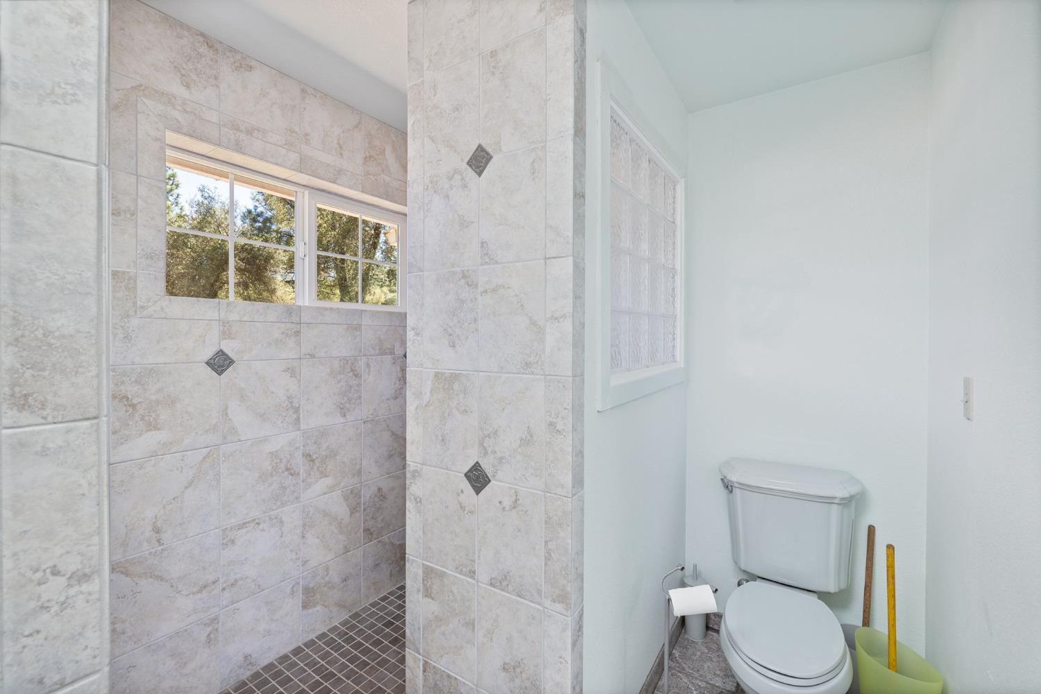 45544 Pine River Road Ahwahnee, CA 93601 - Photo 24 of 75 a white toilet sitting next to a bathroom sink