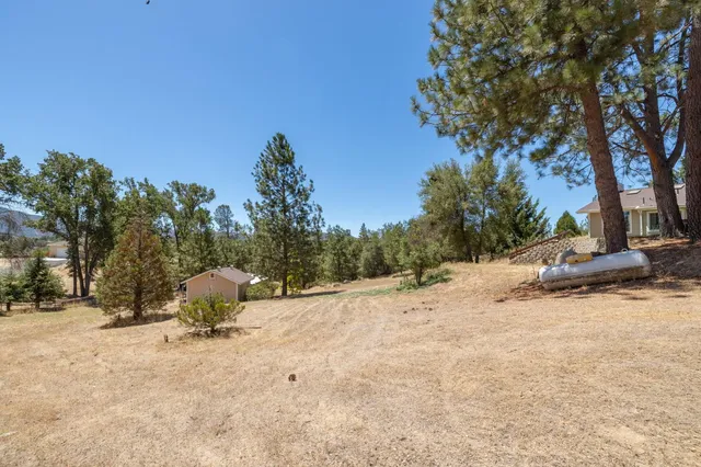 a view of a house with swimming pool lawn chairs and a yard