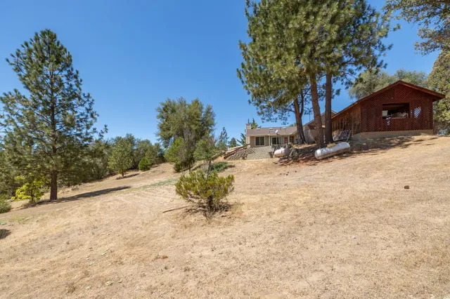 a view of a house with backyard and sitting area