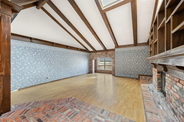 a view of an empty room with a fireplace and a window