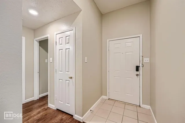 an empty room with wooden floor & closet area