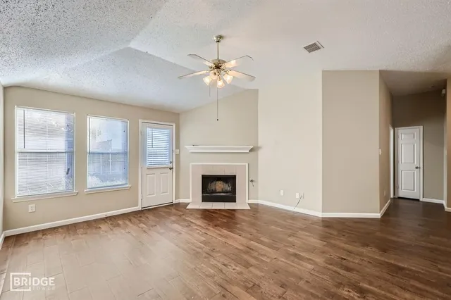wooden floor fireplace and windows in an empty room