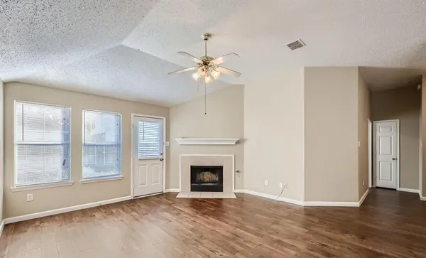 a view of an empty room with window and chandelier fan