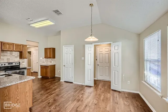a view of a room with wooden floor fireplace and windows