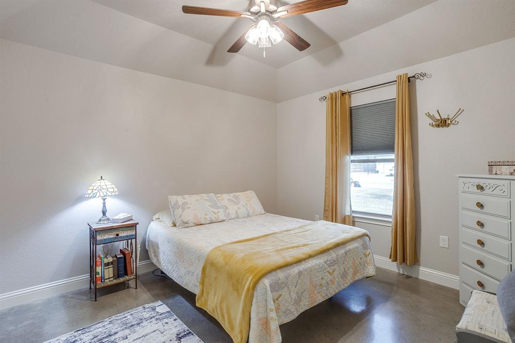 111 Treys Way Godley, TX 76044 - Photo 28 of 38 a bedroom with a bed and a chandelier