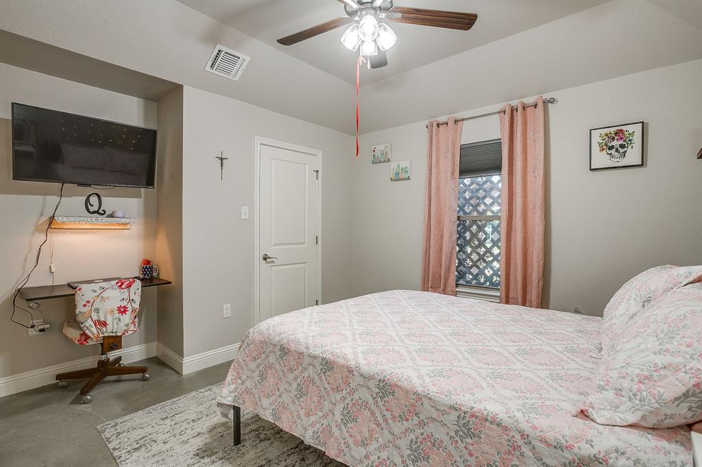 111 Treys Way Godley, TX 76044 - Photo 30 of 38 a bedroom with a bed and a chandelier