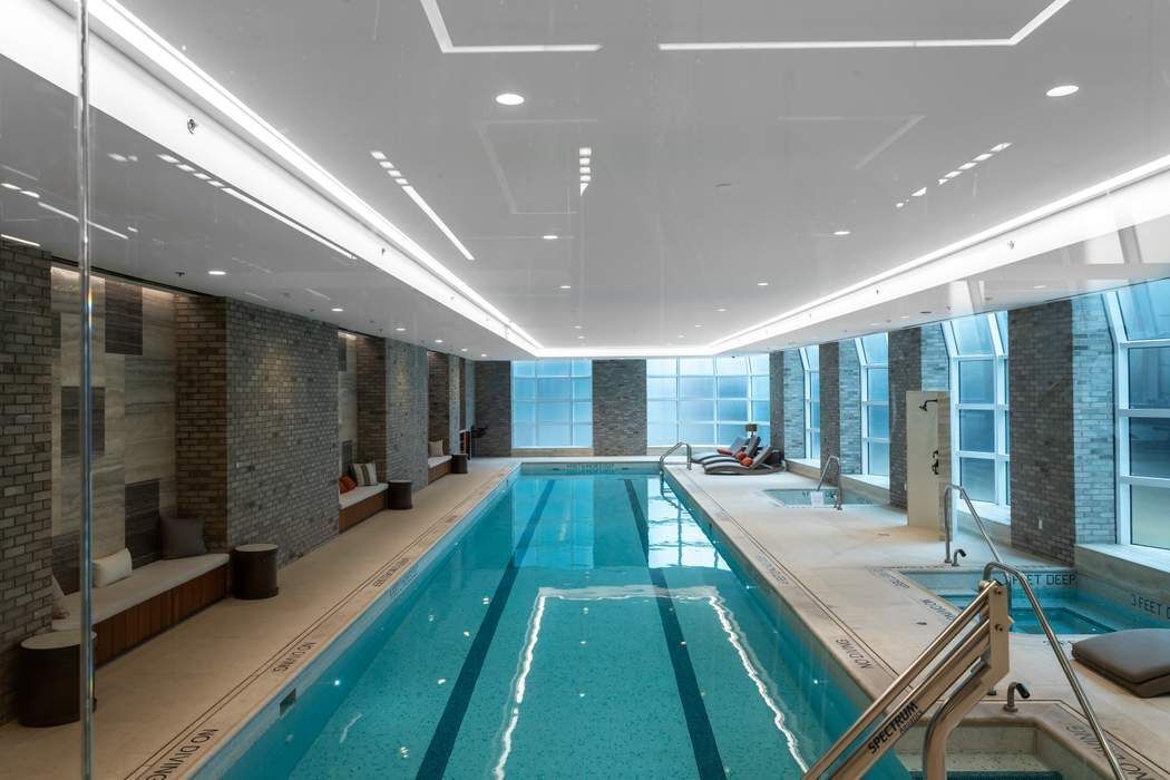 515 West 18th Street, Unit 308 Manhattan, NY 10011 - Photo 10 of 16 a living room with stainless steel appliances lots of white furniture wooden floor and a rug