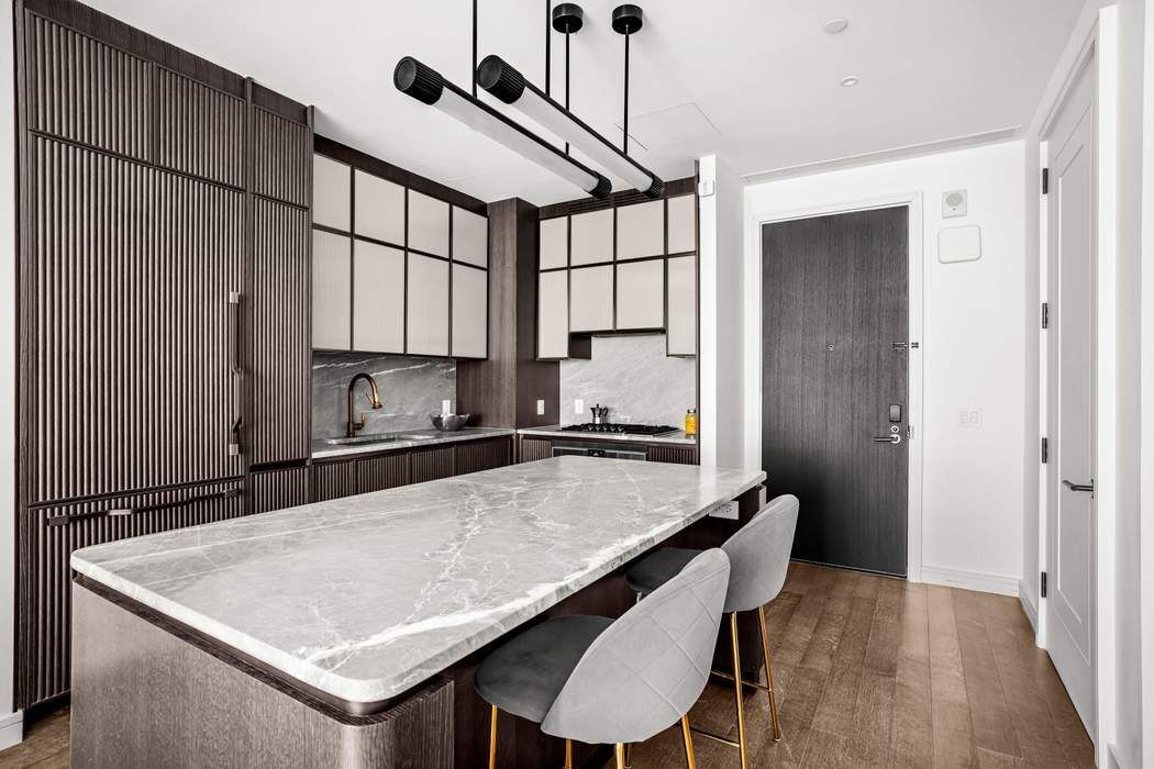 515 West 18th Street, Unit 308 Manhattan, NY 10011 - Photo 3 of 16 a kitchen with a table chairs sink and cabinets