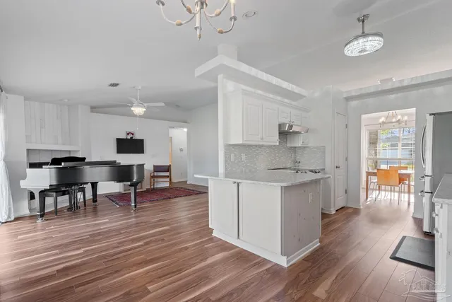 a large kitchen with cabinets wooden floor and stainless steel appliances