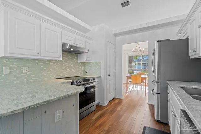 a kitchen with stainless steel appliances granite countertop a refrigerator sink and cabinets