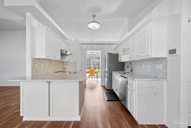 a kitchen with cabinets and wooden floors