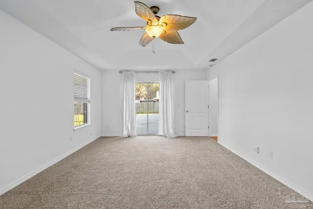 an empty room with closet and a chandelier fan