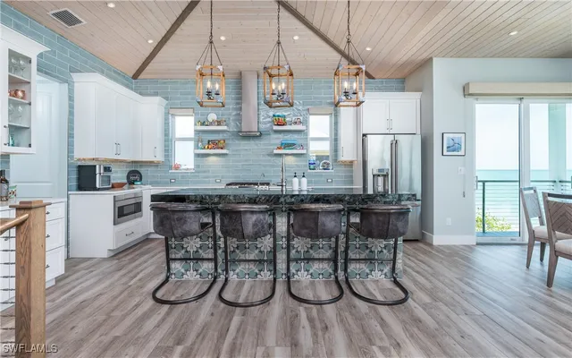 a kitchen with a table chairs refrigerator and cabinets