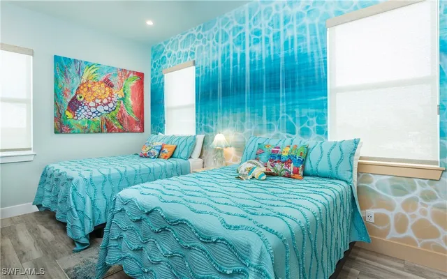 a bedroom with two beds and a painting on the wall