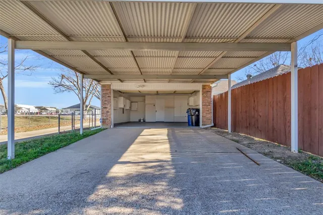 a view of an empty room with wooden floor and a ceiling fan