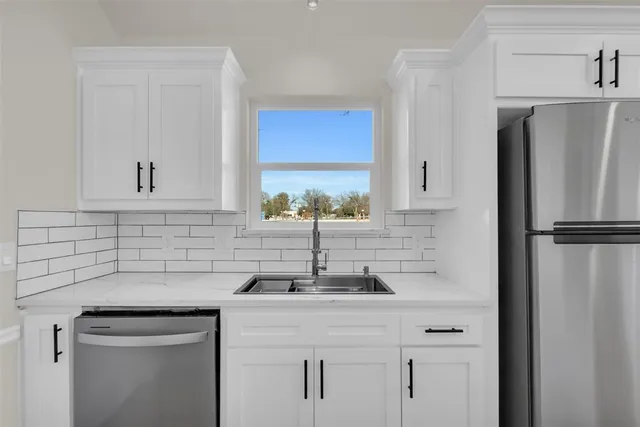 an empty room with windows and fireplace