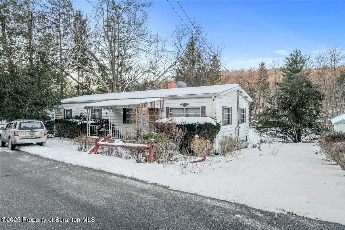 2099 Turnpike Road Dalton, PA 18414 - Photo 1 of 16 a view of a patio with table and chairs under an umbrella with large trees