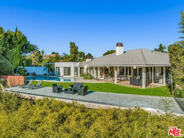 an aerial view of a house with swimming pool and patio