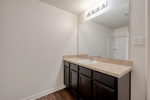 a bathroom with a granite countertop sink and a mirror