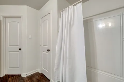 a view of a room with wooden floor and entryway