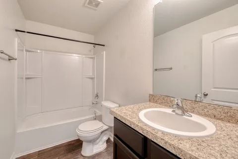 a bathroom with a granite countertop sink toilet and shower
