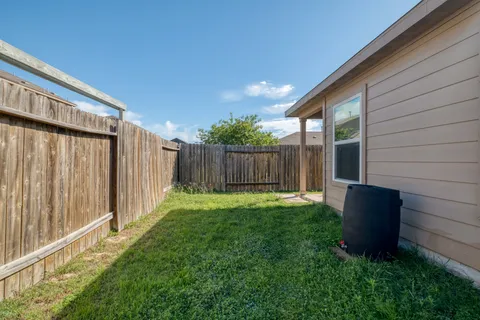 a view of backyard with potted plants and wooden fence