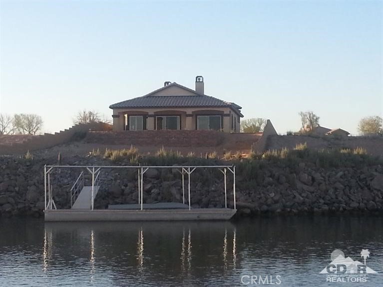 a view of house with river and trees in the background