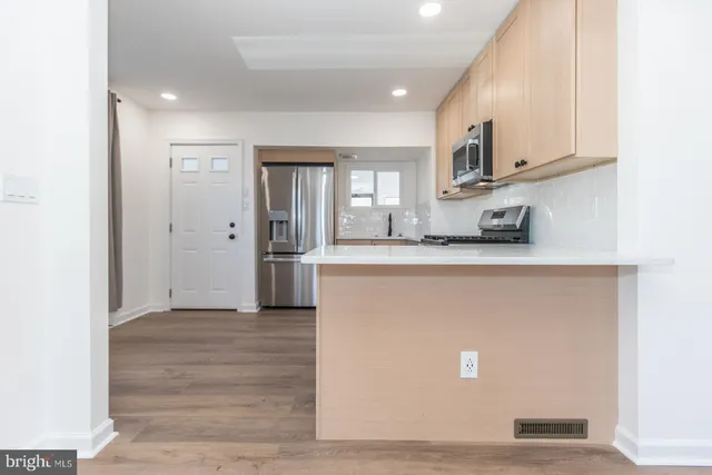 a kitchen with a refrigerator and a stove top oven