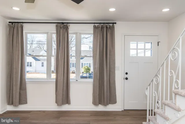 a view of empty room with wooden floor and window