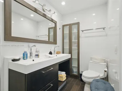 a bathroom with a sink toilet and a mirror