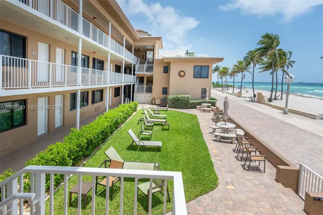 a view of a house with backyard and sitting area