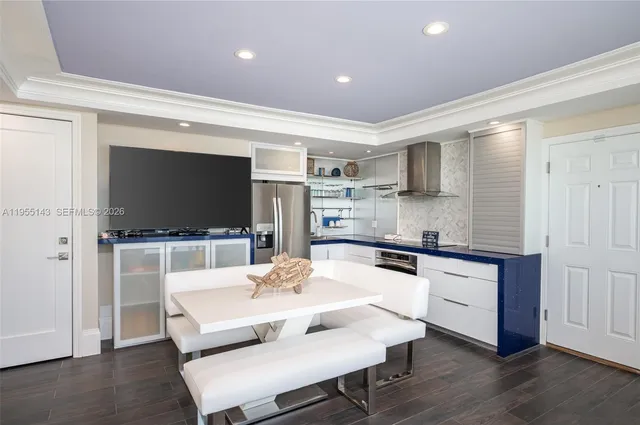 a kitchen with stainless steel appliances a stove a sink and a living room