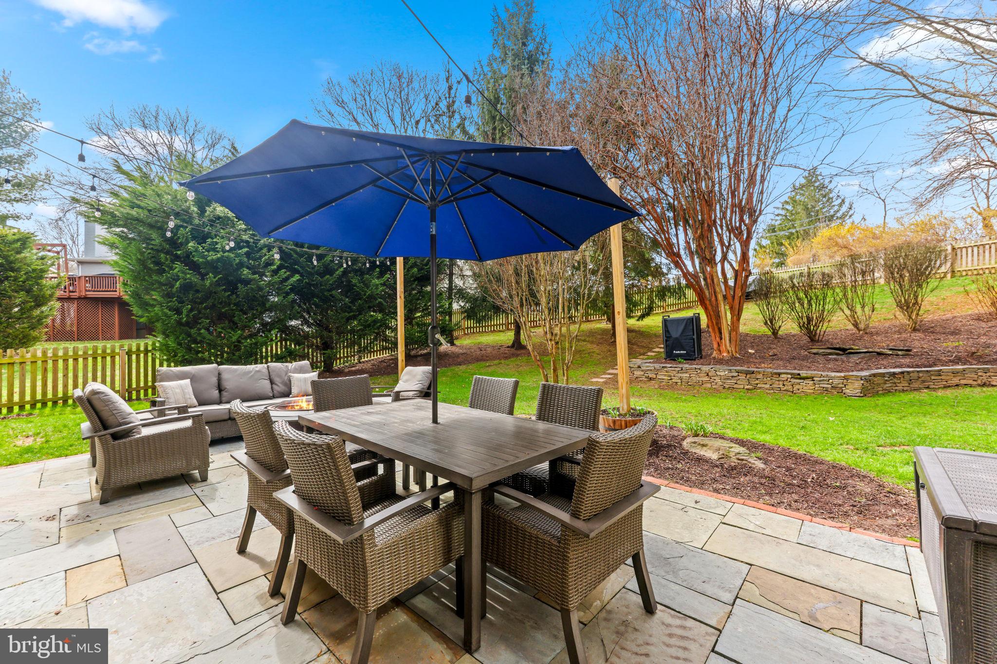 6513 Apple Blossom Ride Columbia, MD 21044 - Photo 103 of 115 a view of patio with chairs and table under an umbrella