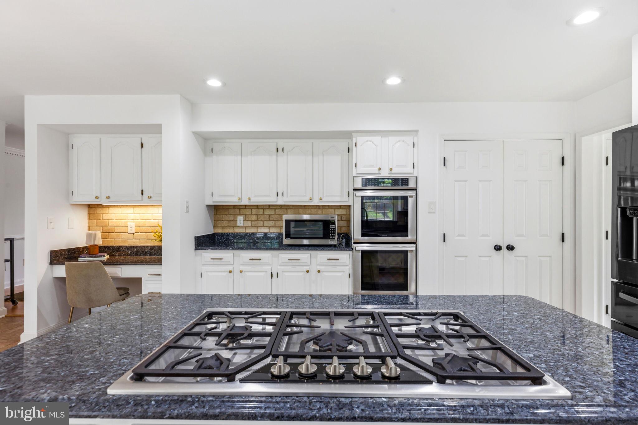 6513 Apple Blossom Ride Columbia, MD 21044 - Photo 30 of 115 a kitchen with kitchen island granite countertop a sink stove and refrigerator