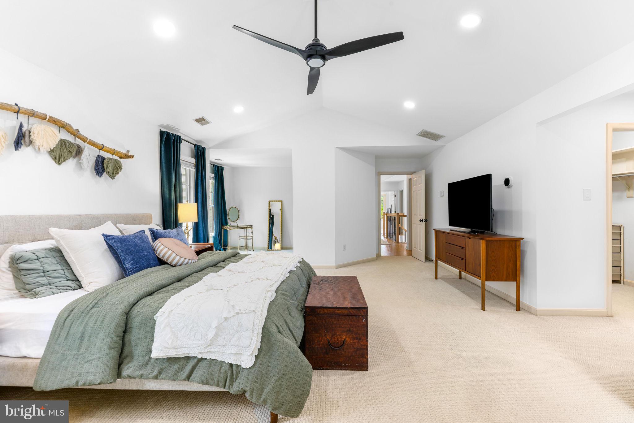 6513 Apple Blossom Ride Columbia, MD 21044 - Photo 42 of 115 a spacious bedroom with a bed and a flat screen tv