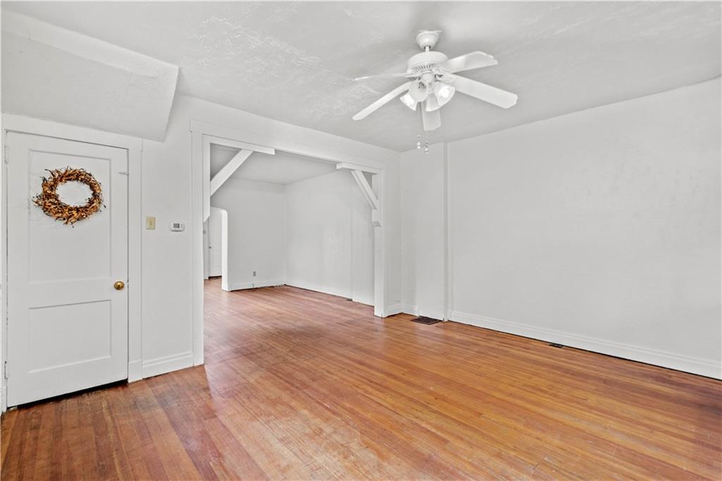 2927 Willett Road Pittsburgh, PA 15227 - Photo 8 of 24 an empty room with wooden floor chandelier fan and windows