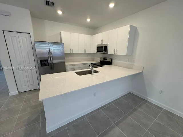 a kitchen with a refrigerator and a sink