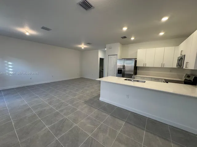 a kitchen with a refrigerator sink and stove