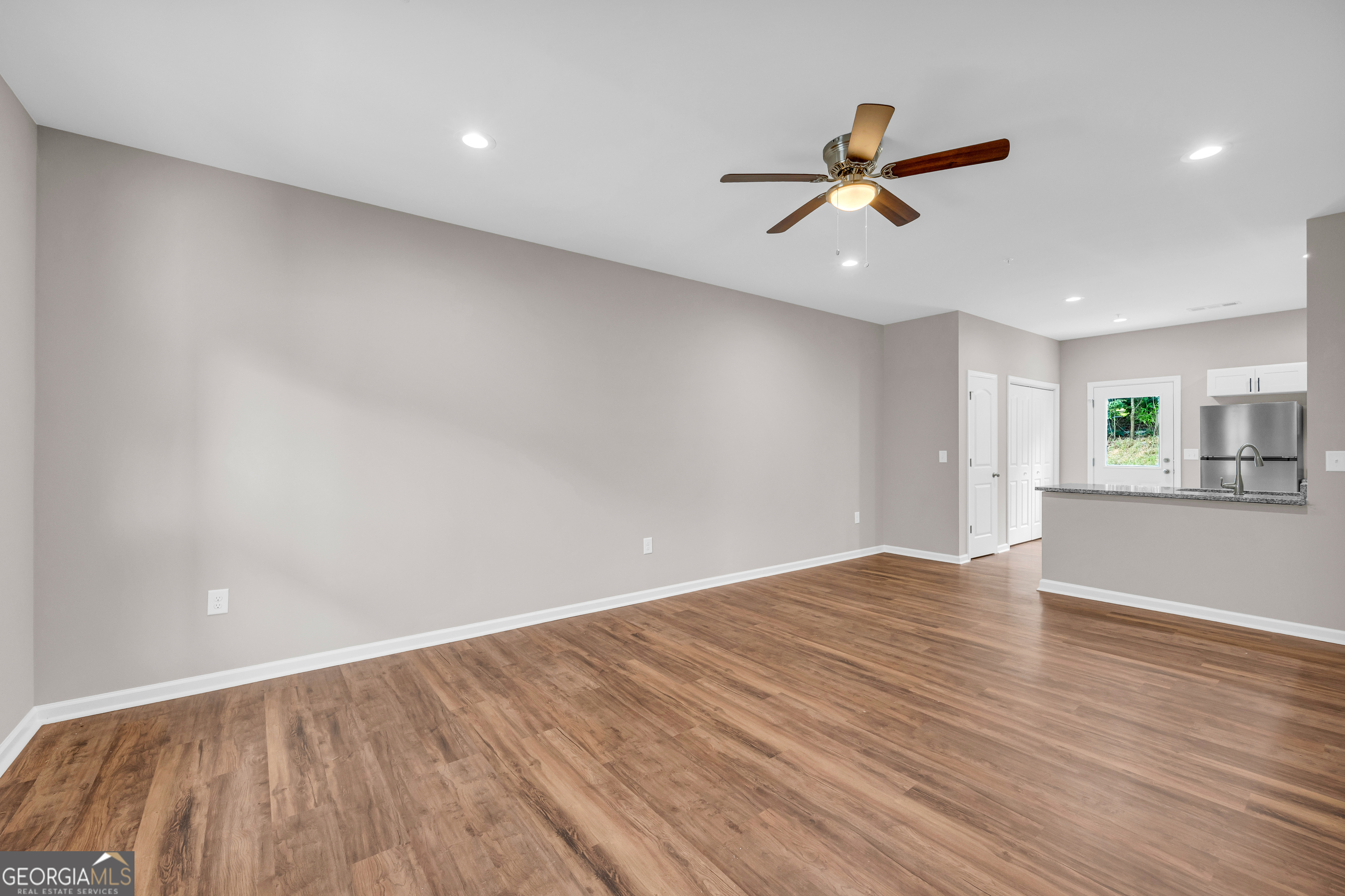 339 A Gainesville Street Carnesville, GA 30521 - Photo 7 of 19 an empty room with wooden floor ceiling fan and windows