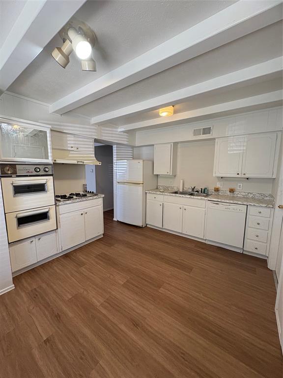 3717 Swallow Lane Irving, TX 75062 - Photo 6 of 11 Kitchen with beam ceiling, white cabinets, freestanding refrigerator, dark wood-style floors, and dishwasher