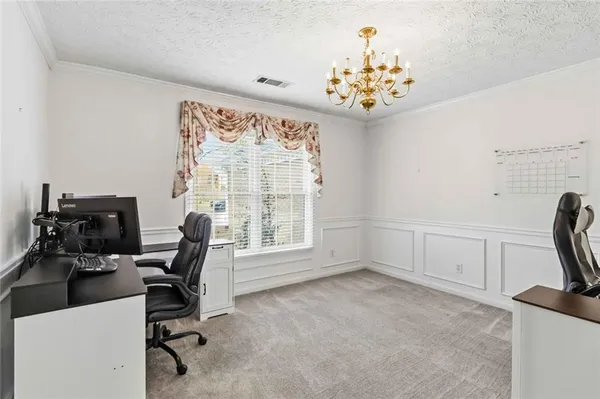 a view of an empty room and chandelier fan