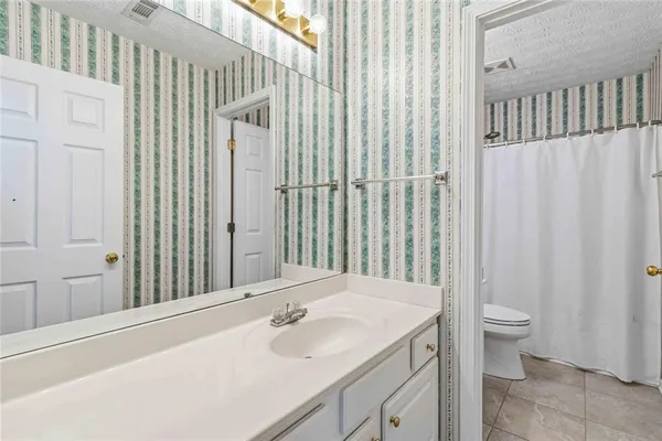 a bathroom with a sink a toilet and shower curtain