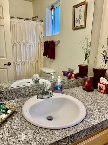 a bathroom with a granite countertop sink and a mirror