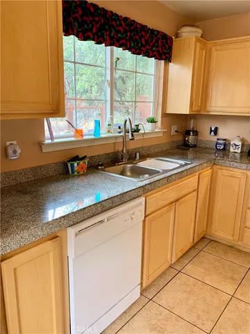 a kitchen with stainless steel appliances granite countertop a sink a stove and white cabinets next to a window